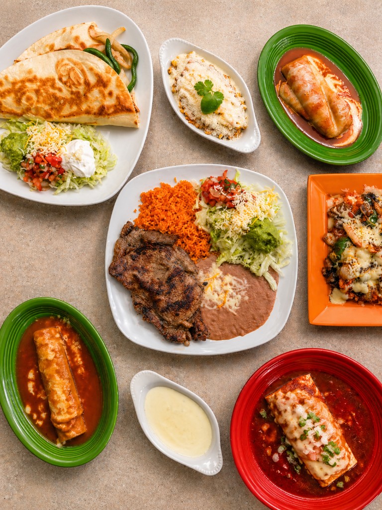 Variety of Mexican dishes — carne asada, enchiladas, quesadillas, and elote